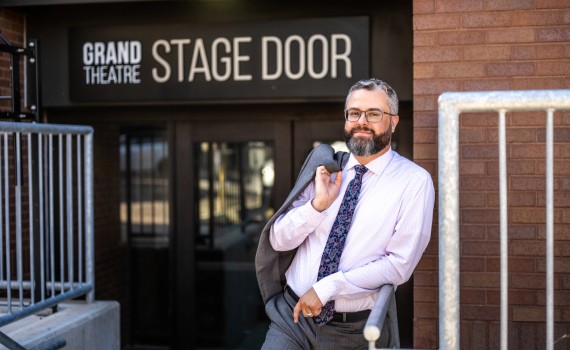 Evan Klassen stands at the stage door of the Grand Theatre
