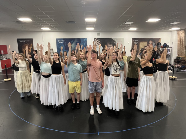 The cast of The Phantom of the Opera stand in formation as they rehearse a scene of the production.