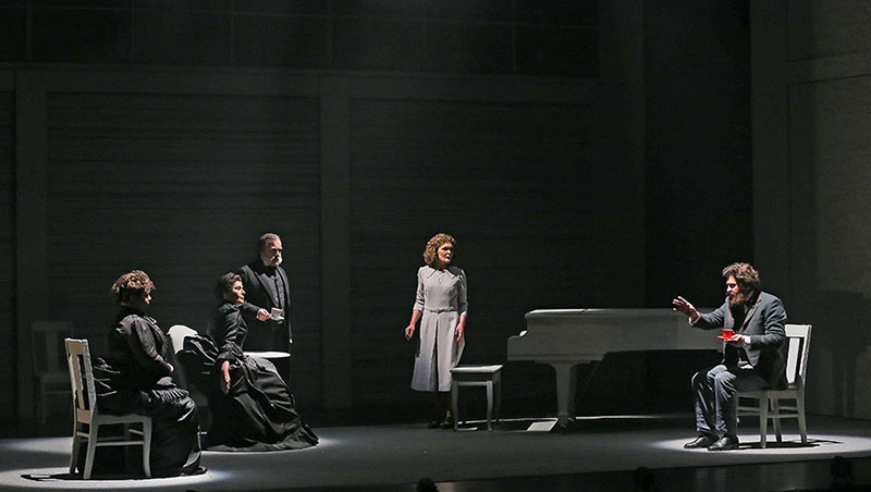 The cast of Silence listens to a man speak during a scene in the play.