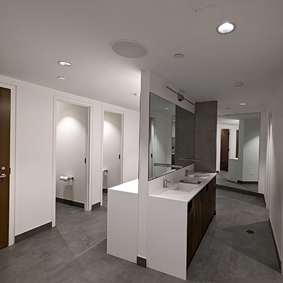 A view inside an all-gender washroom, showing the private stalls with floor-to-ceiling doors and walls.