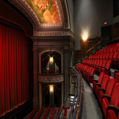 An angled view of the Spriet Stage with its curtains closed, showing both the orchestra and balcony level seating.