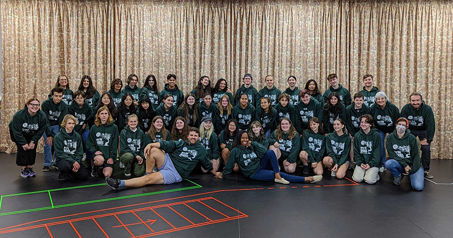 Photo of Saccha Dennis and Greg Carruthers posing with the student cast and crew of Into the Woods