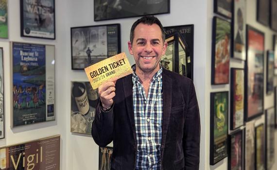 Dennis Garnhum smiles as he holds up a golden ticket.