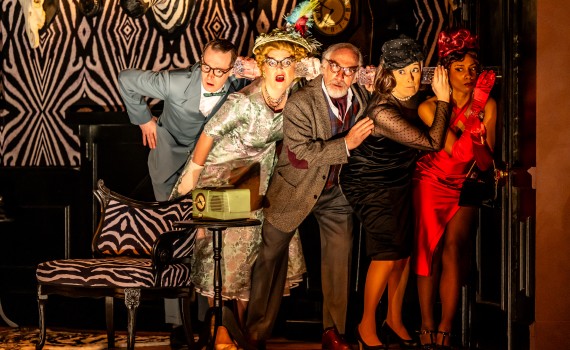 Fancy dress dinner guests use cups to listen through a closed door.