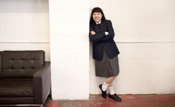 Neela Noble as Matilda, leaning against a brick wall.