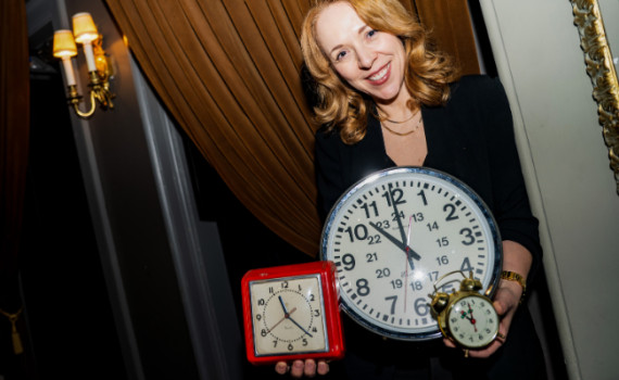 Rachel Peake with her arms full of clocks.