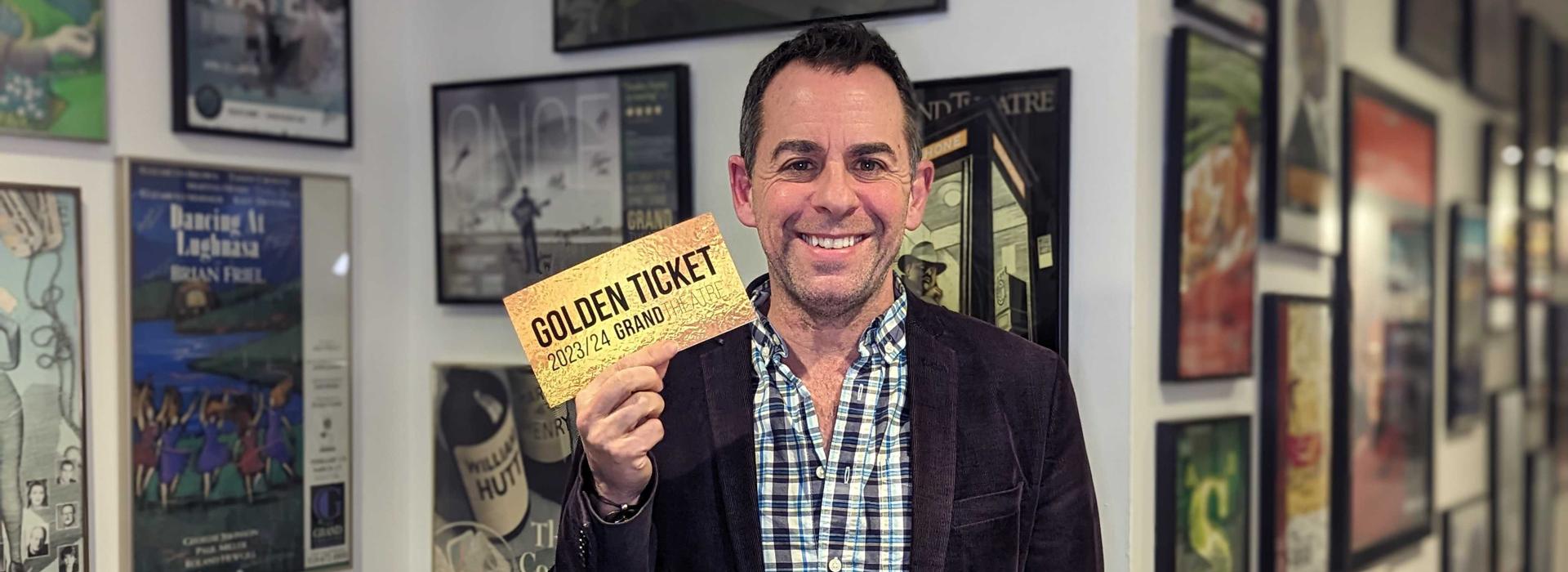 Dennis Garnhum smiles as he holds up a golden ticket.