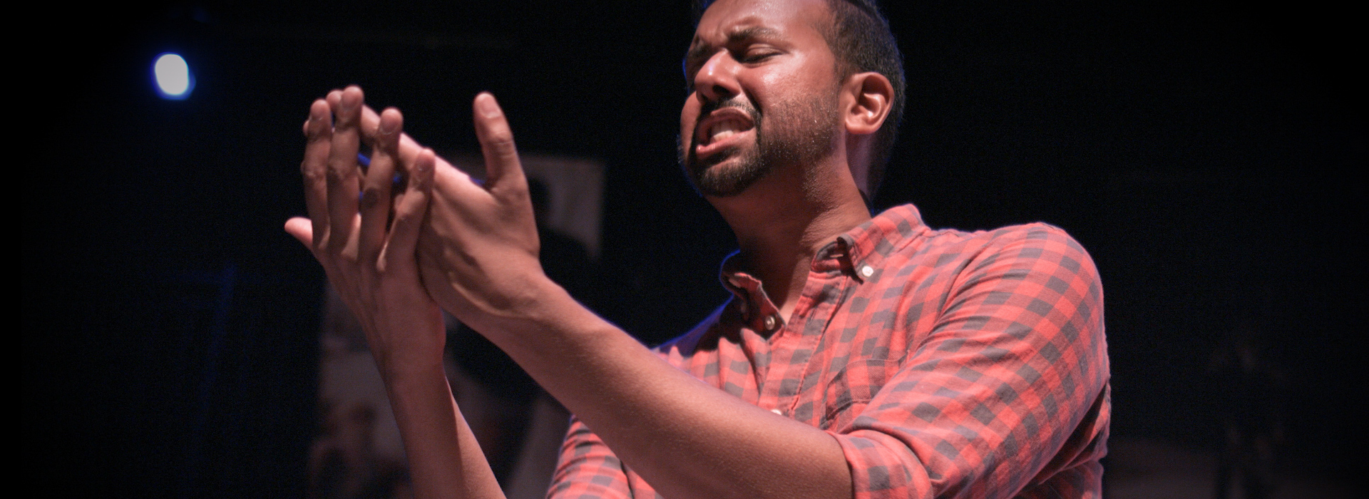 Andrew Prashad faces his own outstretched hands with great emotion.