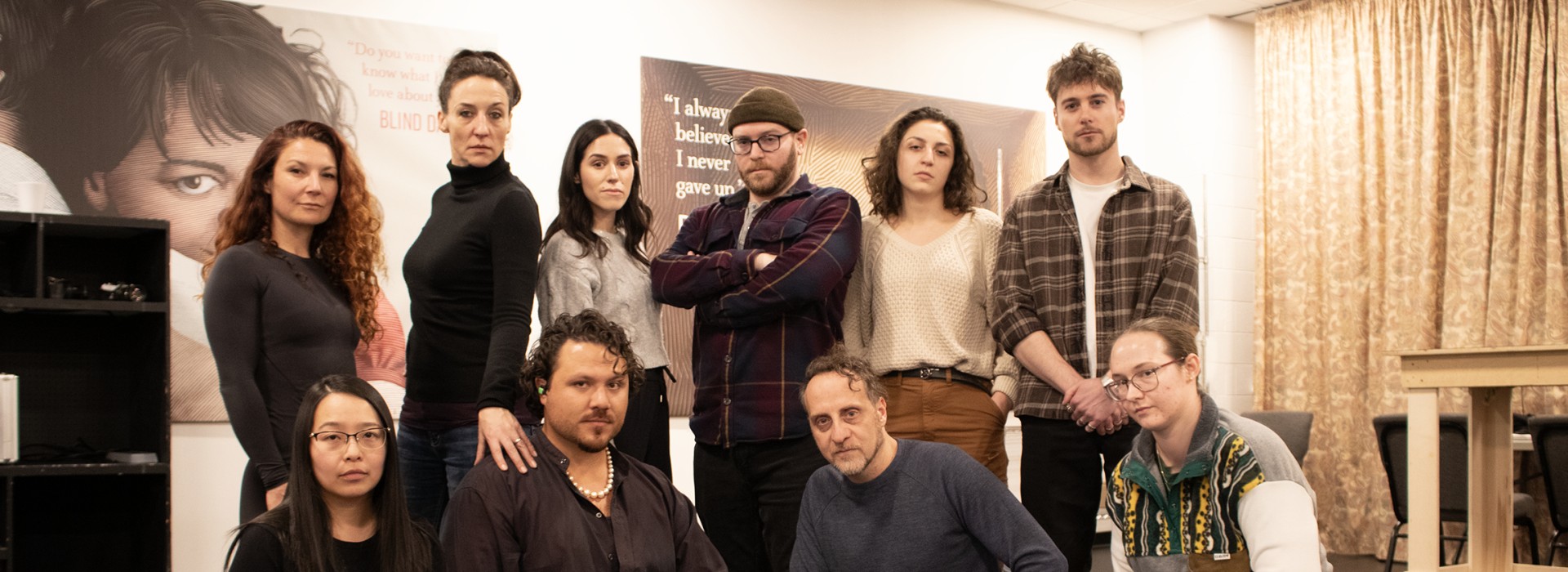 The HEIST team poses around an open briefcase in the rehearsal hall.
